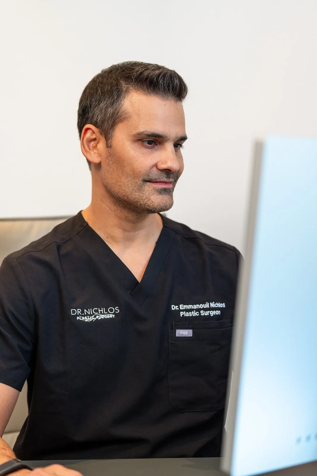 Dr. Emmanouil Nichlos am Schreibtisch in seiner Praxis in Frankfurt